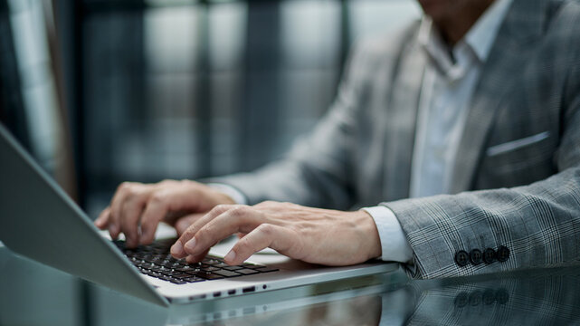 Professional man types on laptop at sleek desk