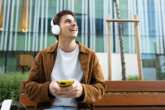 Young man enjoying music with headphones in urban setting