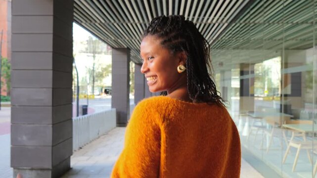 A woman walks confidently, embodying a sense of purpose and determination in a lively urban space filled with energy and life, showcasing a moment of personal reflection and movement.