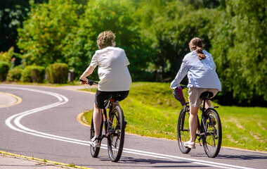 Naklejka premium Cyclists ride on the bike path in the city Park
