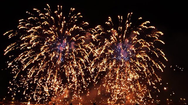 Vibrant fireworks exploding in the night sky with smoke and lights