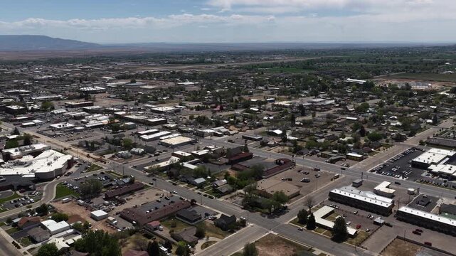 High aerial over small desert town of Vernal Utah in valley sunny spring day