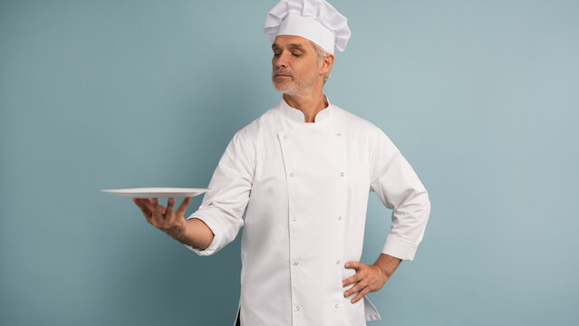 Portrait of chef, empty plate and smile, presenting menu special promo deal or restaurant product placement