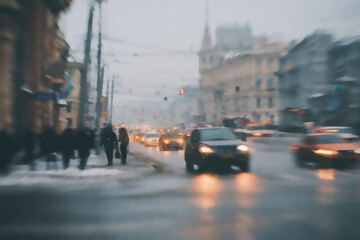Obraz premium Snowy city street with blurred cars, pedestrians, and buildings