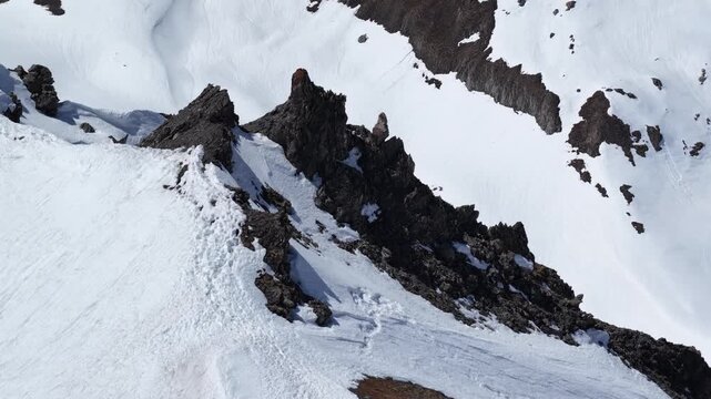 Sunny drone view of Tignes and Grande Motte glacier surrounded by snowy mountains in the French Alps during spring. Drone view of alpine glacier and snowy mountain peaks in French Alps
