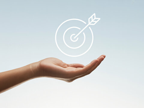 Hand holding target icon for business goal and success concept