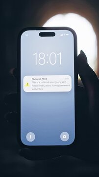 Vertical video. Smartphone Displaying National Emergency Alert Inside Dark Tunnel With Bright Light Background, Cinematic Crisis Communication Scene About Government Warning System