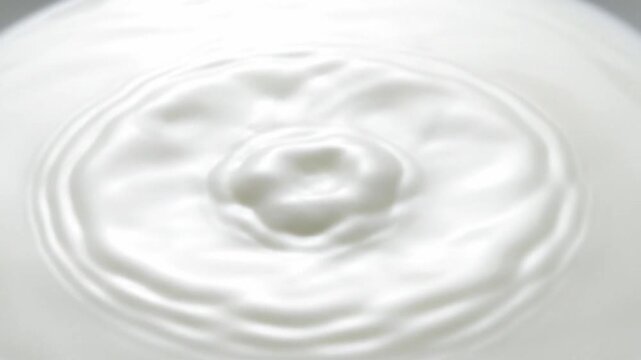 Liquid splash sequence showing milk impact and ripple effect in white bowl setting