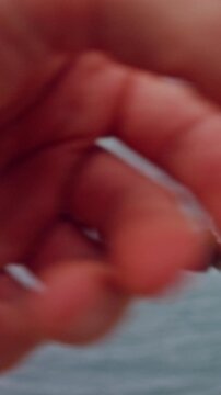 Vertical video. Close Up First Person View of Hand Reaching for Spinning Reel During Fishing Cast Near Tropical Coastline, Active Saltwater Recreation