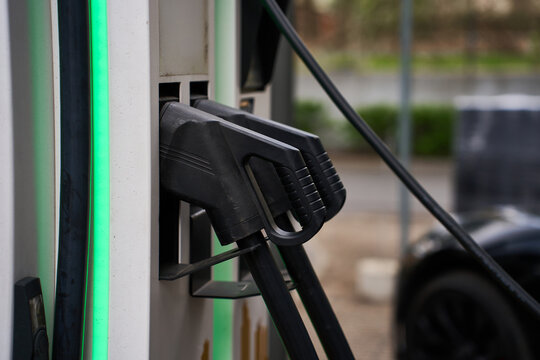 Close up of heavy-duty DC charging plugs at a fast EV charging station.
