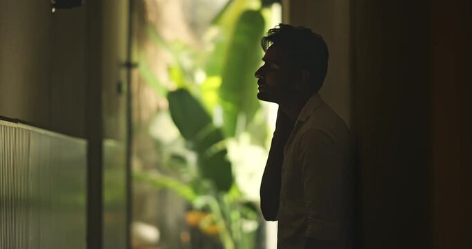 Indian young adult gen z sad stress man guy look upset feel bad hurt head ache in dark living room. Alone tired male boy think deep suffer low health issue lost job fail guilt indoor house home place