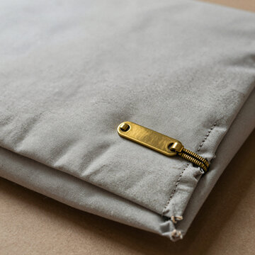 Close up of a raw canvas shipping envelope with brass zip