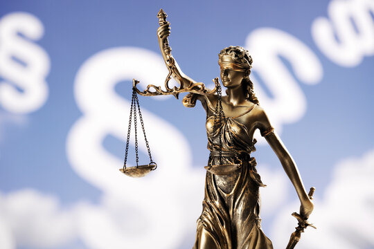Justitia figurine in front of paragraphes