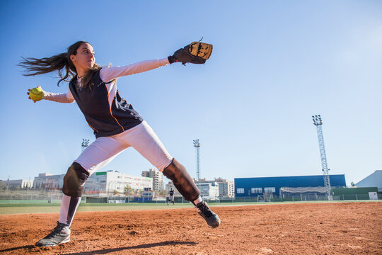 Female baseball player throwing the ball during a baseball game