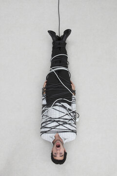 Businessman tied up with computer cable, elevated view