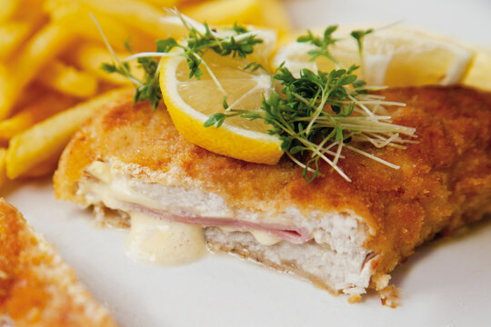 Cordon bleu with potato fries and sauce hollandaise, close up