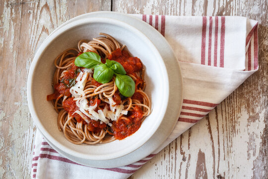 Bowl with spelt whole grain spaghetti, tomato sauce, parmesan and basil