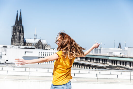 Germany, Cologne, woman dancing on roof terrrace