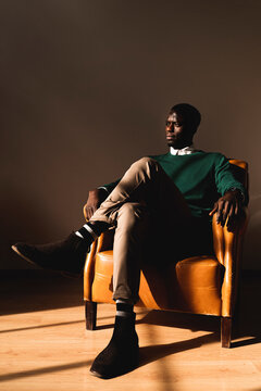 Man sitting in leather armchair looking sideways