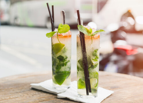 Two glasses of Mojito on table of sidewalk cafe