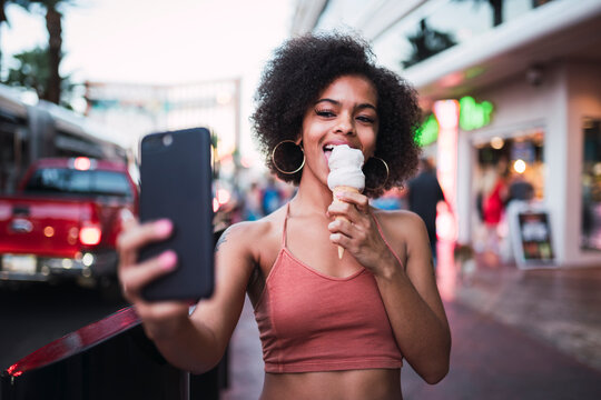 USA, Nevada, Las Vegas, happy young woman eating ice cream in the city taking a selfie