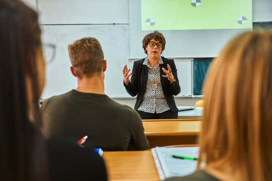 Lecturer talking to students in auditorium at university
