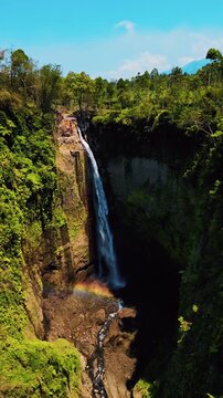 Cinematic aerial view of Kapas Biru waterfall in East Java &ndash; Breathtaking drone shot of the dramatic jungle canyon and majestic cascade during beautiful morning sunrise in Indonesia 4k