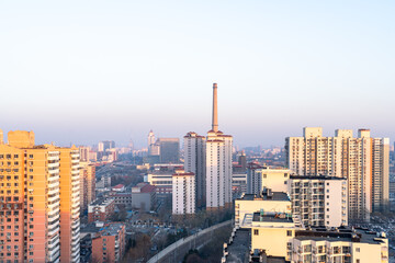 Fototapeta premium The urban skyline of Beijing, China, blends industrial chimneys with modern residences.