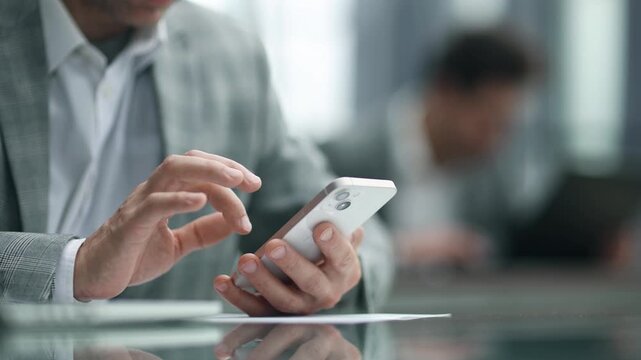 Hand taps phone screen, focused on task