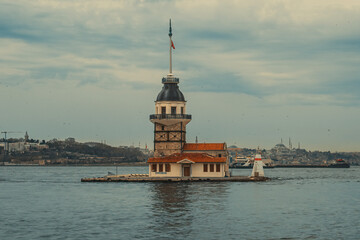 Obraz premium Maidenâ€™s Tower in Istanbul stands beautifully over the Bosphorus, creating a striking view with its historic structure and serene waterfront atmosphere.