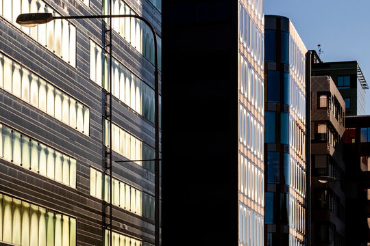 Light and shadow divide a modern office building facade in Stockholm, Sweden, pulling urban city architecture into a narrow street perspective
