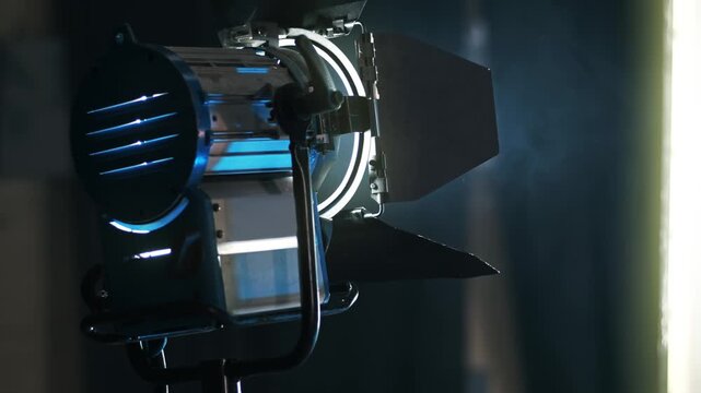 Professional studio lighting equipment fresnel lens spot light with barn doors on film set.