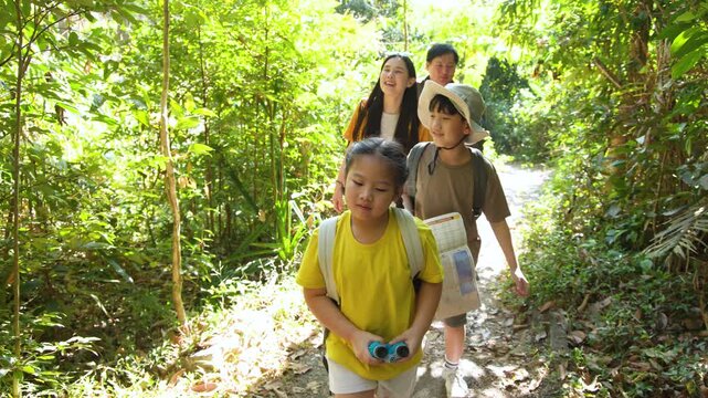 Asian Family with Young Children Hiking Through Lush Green Tropical Jungle