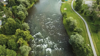 Fototapeten Wald Fluss Mountain river flowing through small countryside village  © AlexGo