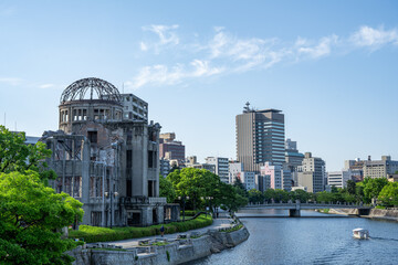 Naklejka premium Atomic Bomb Dome Against Blue Sky with Green Trees and Copy Space