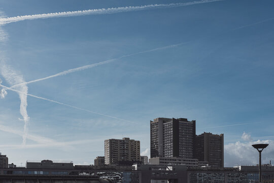 A broad skyline defines the urban cityscape of Paris, France, where towers meet a bright horizon beneath open sky, thin clouds and daylight