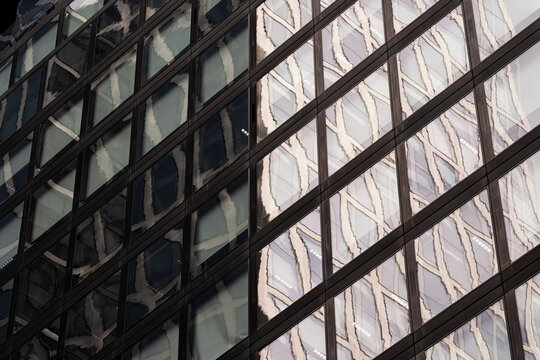 Reflected facades layer across a modern building in Frankfurt, Germany, where urban architecture turns glass geometry into a dense corporate grid