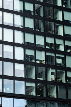 Glass grid and dark facade lines define modern architecture in Frankfurt, Germany, turning an urban building into reflection, pattern and geometry