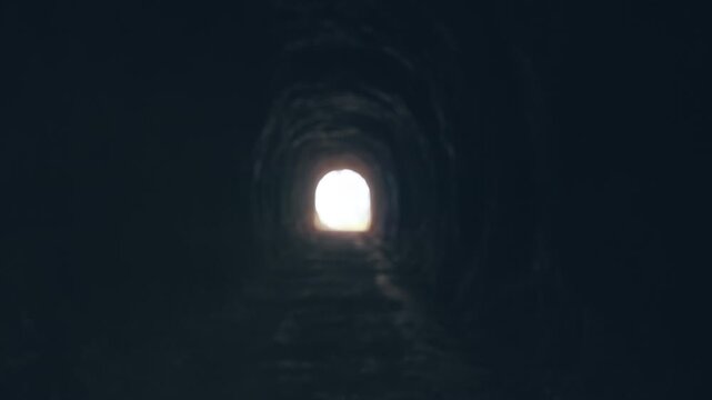 Walking Through Dark Tunnel Toward Bright Light at the End, Handheld Cinematic Point of View Scene About Hope, Escape and Survival Journey