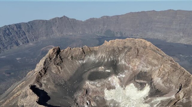 aerial shot looking directly into the rugged crater of Pico do Fogo, with the vast volcanic basin and the Bordeira cliff wall visible in the distance Cabo Verde Drone