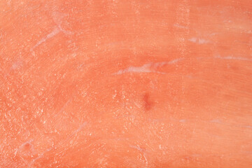 Fototapeta premium Full frame macro view of a pink raw cured ham slice showing smooth surface texture and meat details.