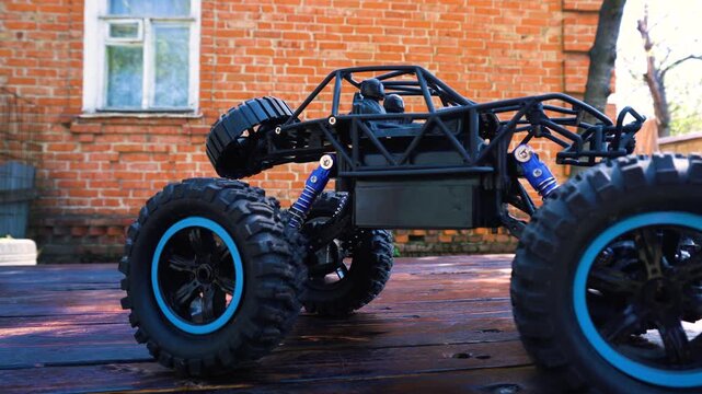 off-road toy cars turn with big tires art creative in water splashes 360 degree rotation on dark background with red backlight