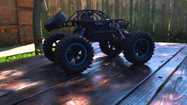 off-road toy cars turn with big tires art creative in water splashes 360 degree rotation on dark background with red backlight