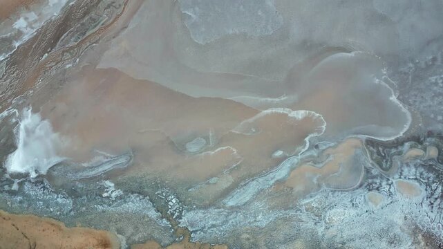 Top down aerial view of Salar de Quisquiro abstract salt patterns with swirling white crust turquoise water channels and sandy sediment textures. Salar de Quisquiro, Chile