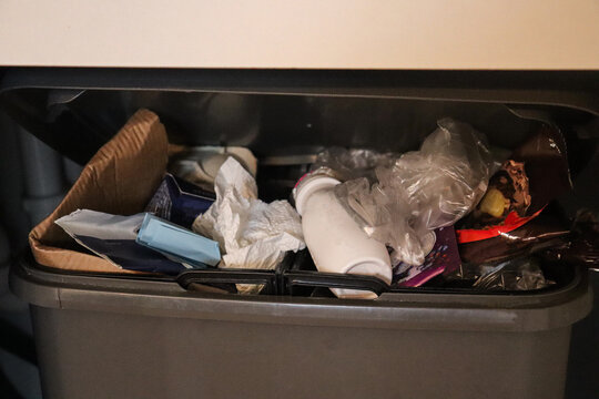 Cat hair, used paper and lots of dust in plastic bucket. Garbage in the bin. Trash rubbish top view.