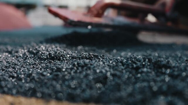 Leveling rubber crumb coating during surface installation close up