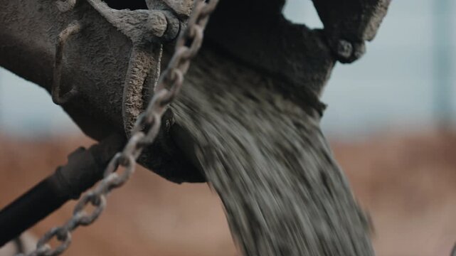 Concrete pouring from construction chute close up