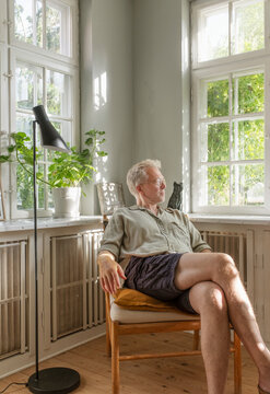 Senior man sitting comfortably on chair at home