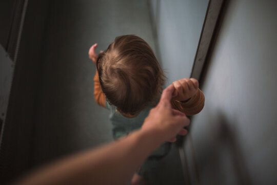 High angle view of boy walking by holding finger of parent