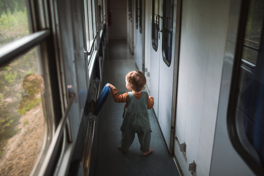 Rear view of carefree boy playing in train aisle